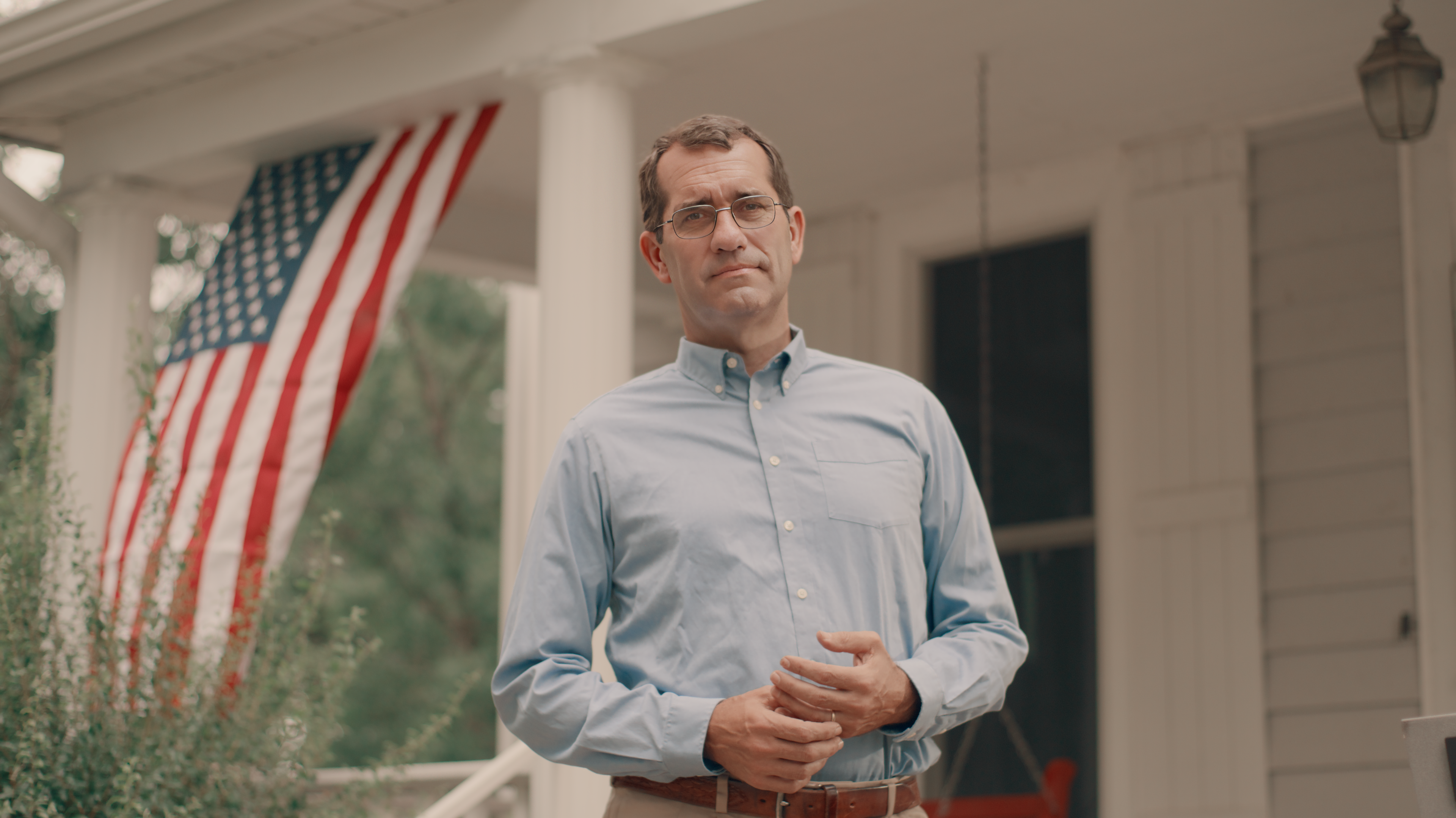 Derek Schmidt standing with a crowd of people waving campaign signs