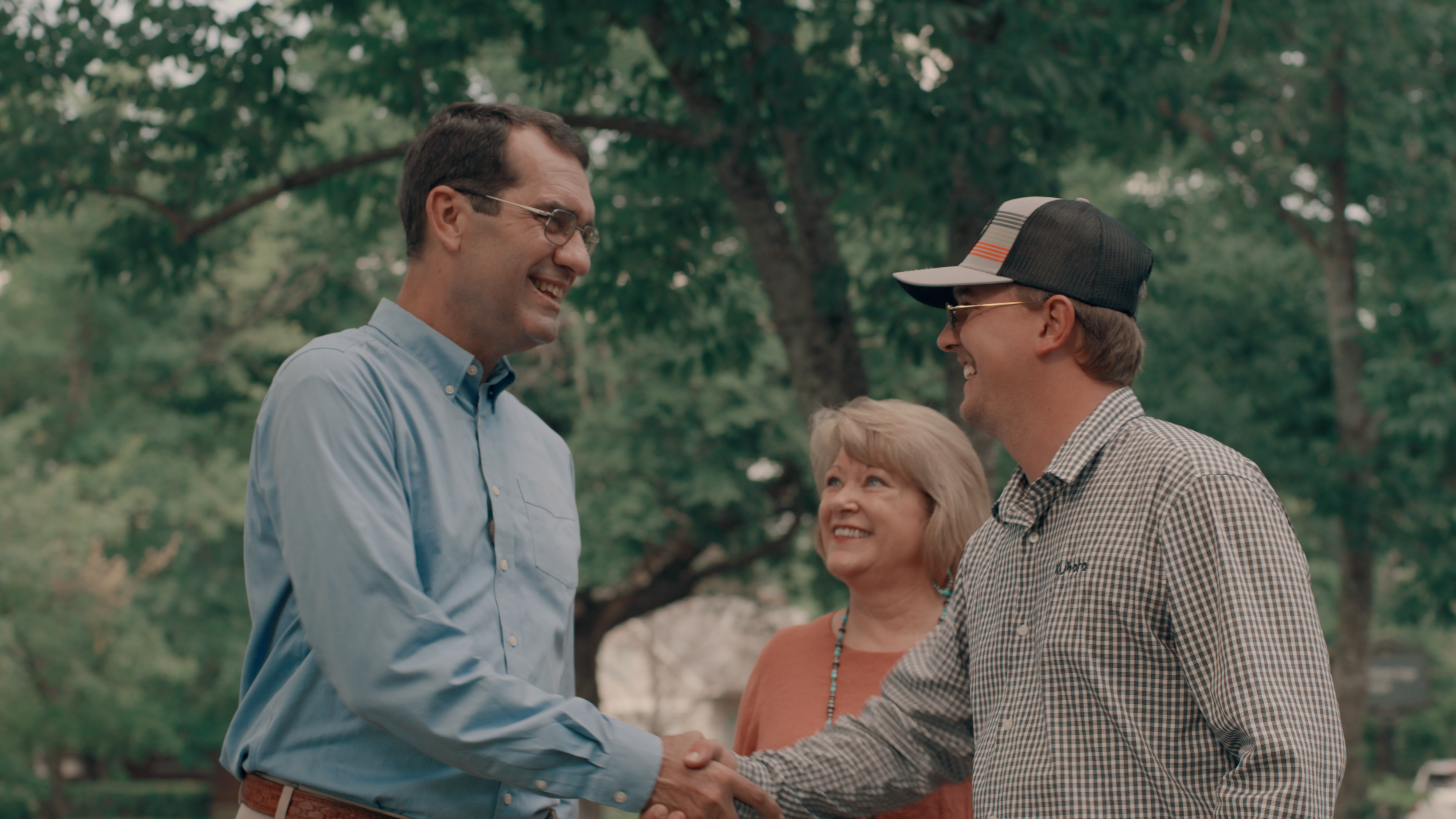 Derek Schmidt standing with a crowd of people waving campaign signs